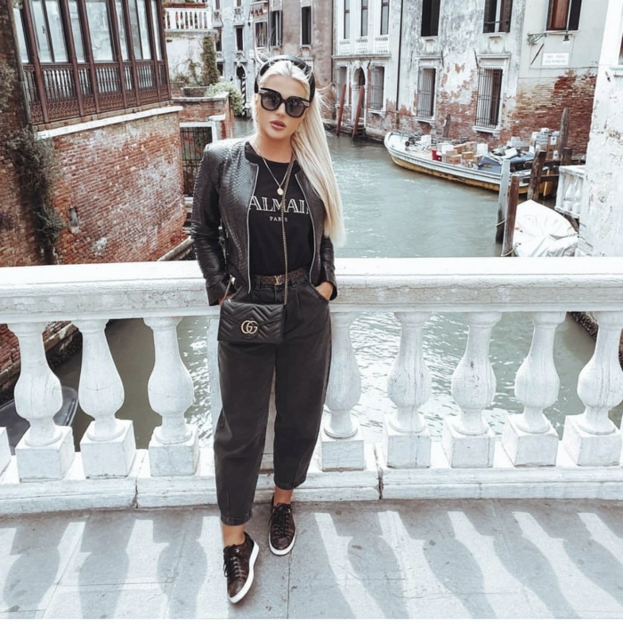 venice street style monochromes schwarzes outfit schwarze mom jeans lederjacke und sneakers blonde frau lange haare