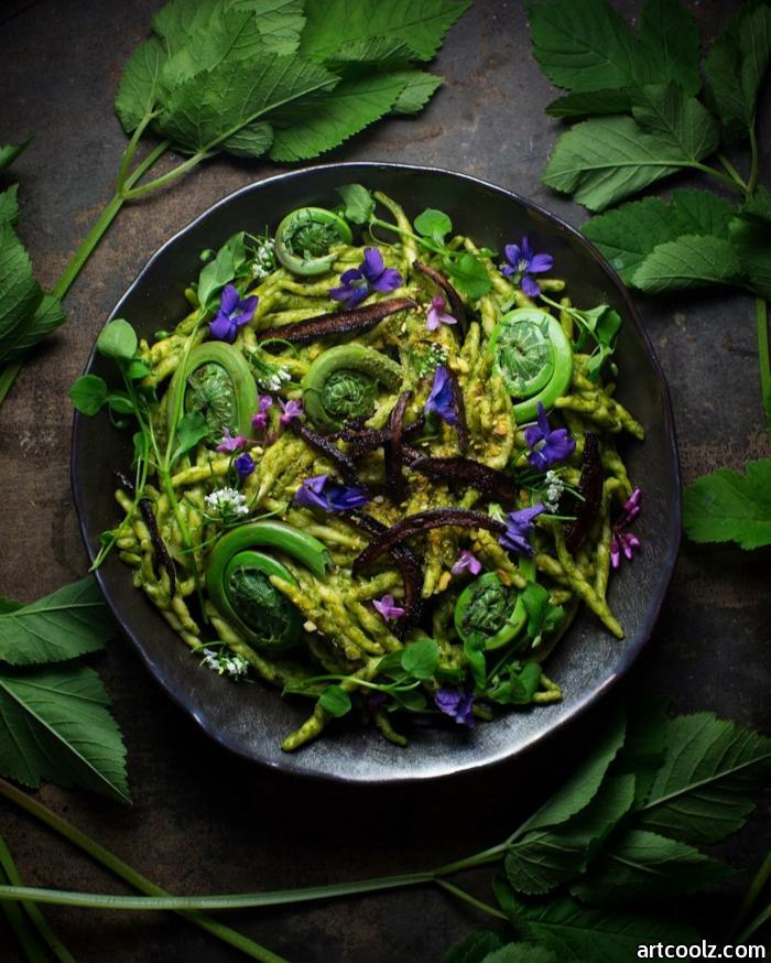 grauer teller mit einem grünen salat mit bärlauch und violetten blumen