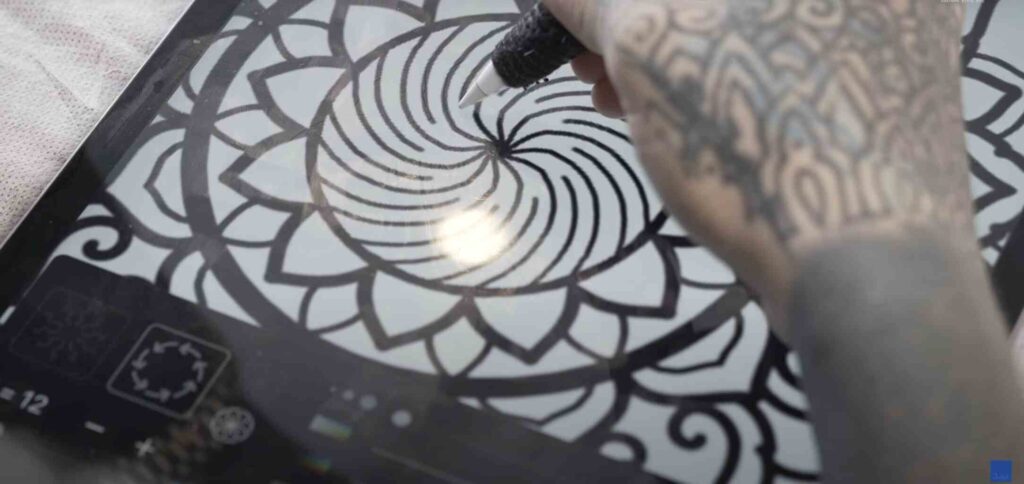 A tattoo artist is creating a new sacred tattoo design on ipad