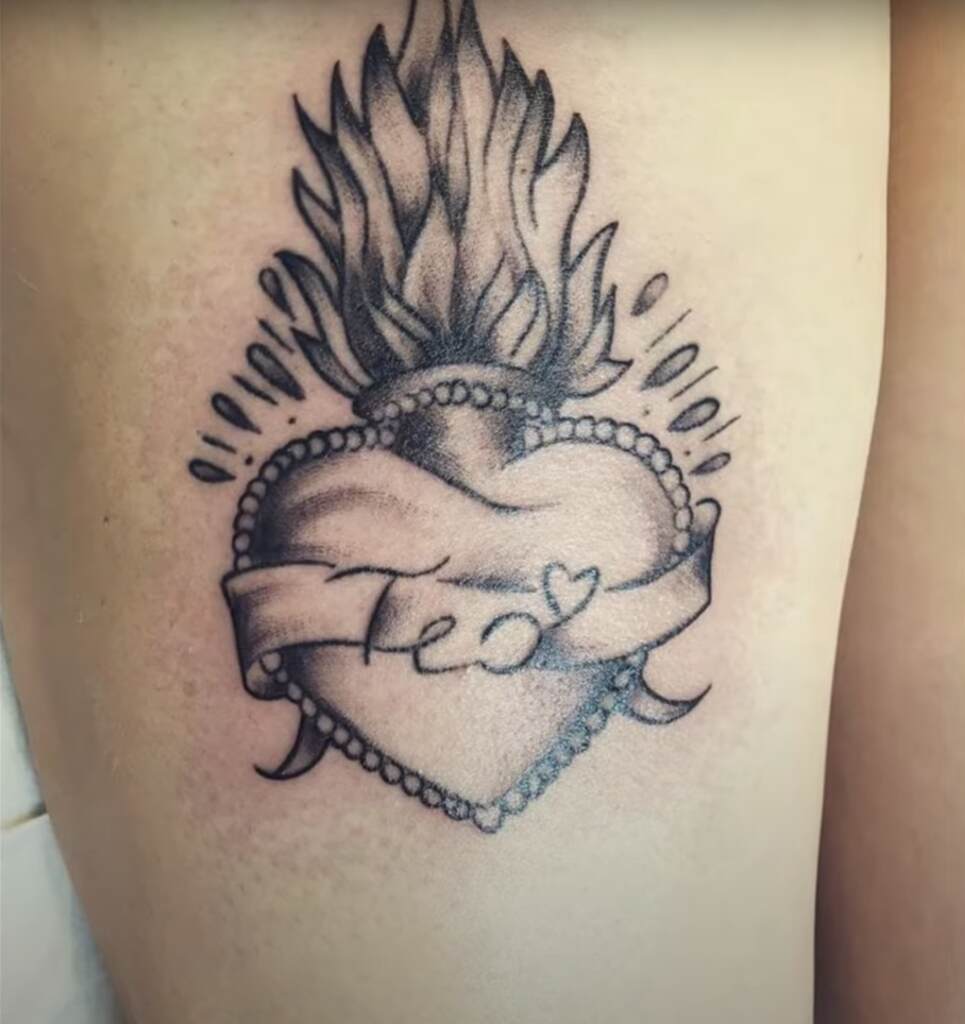 A real Sacred heart tattoo design on man with name "teo" 